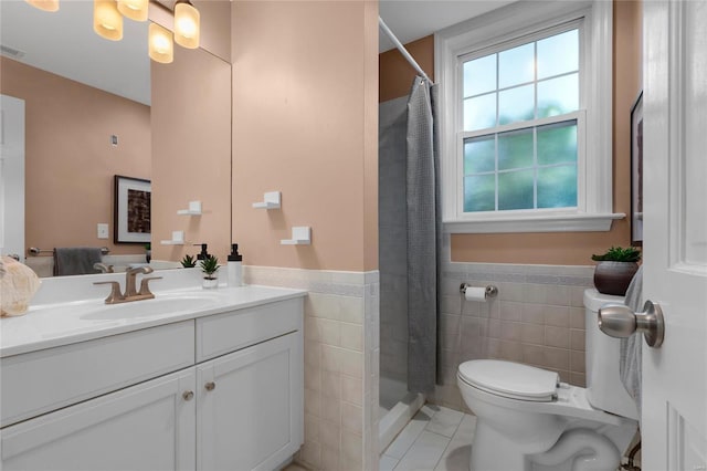 full bathroom featuring toilet, vanity, tile walls, wainscoting, and a stall shower