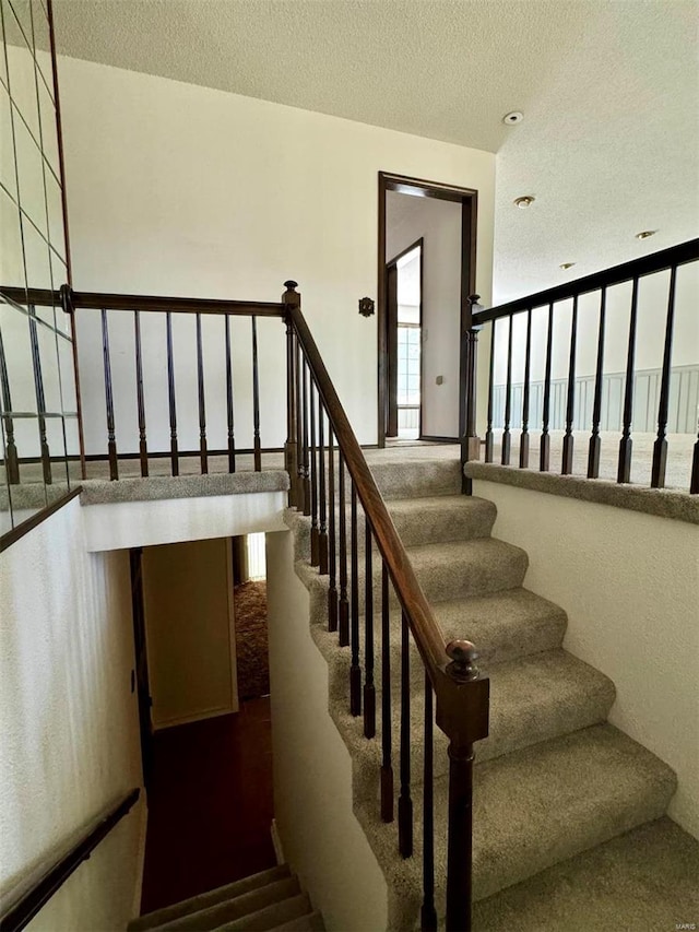 stairs with a textured ceiling