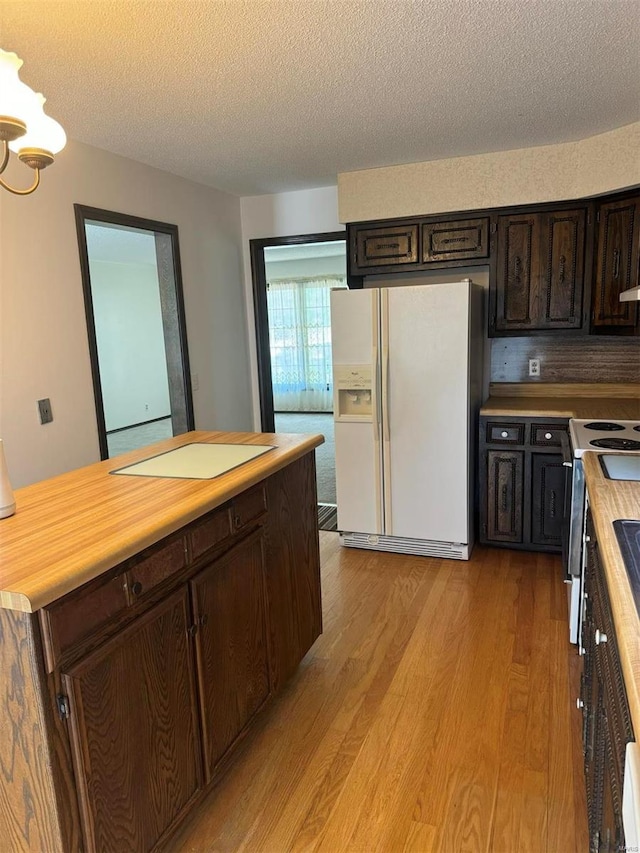 kitchen with a textured ceiling, light wood-style flooring, white refrigerator with ice dispenser, stainless steel range with electric cooktop, and dark brown cabinets