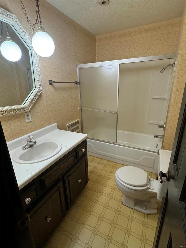 bathroom featuring wallpapered walls, toilet, combined bath / shower with glass door, a textured ceiling, and vanity