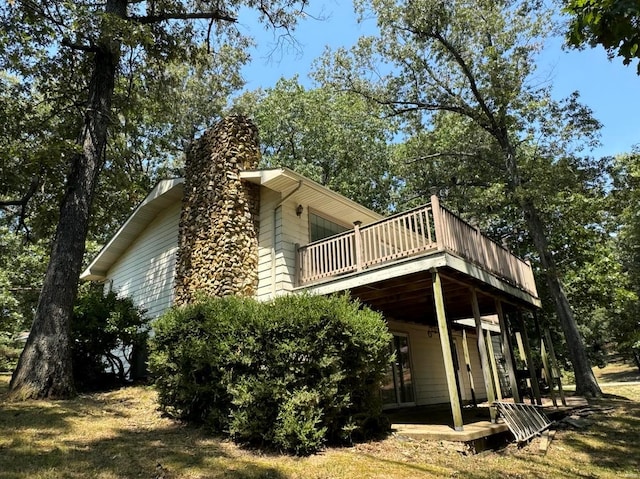 view of property exterior featuring a chimney and a deck