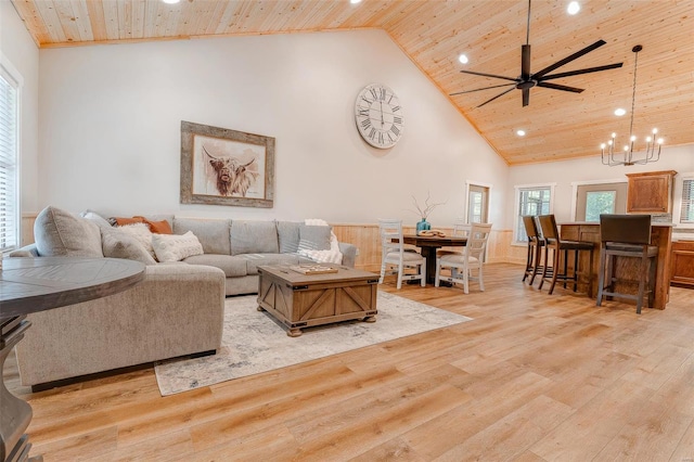 living room with high vaulted ceiling, ceiling fan with notable chandelier, light hardwood / wood-style floors, and wooden ceiling