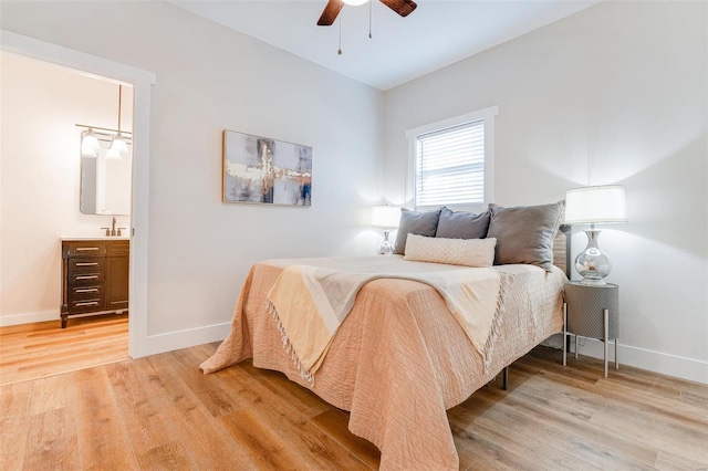 bedroom featuring ceiling fan, ensuite bath, and light wood-type flooring