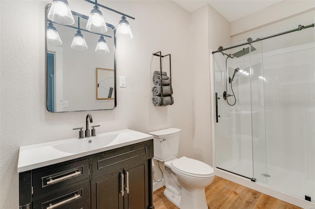 bathroom featuring vanity, toilet, hardwood / wood-style flooring, and an enclosed shower