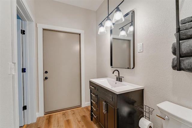 bathroom with vanity, toilet, and hardwood / wood-style flooring