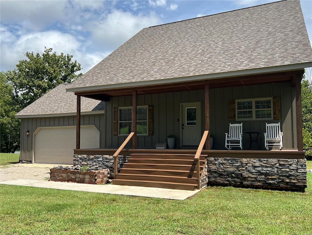 view of front of house featuring a front lawn, a garage, and a porch