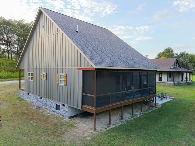 rear view of house with a lawn and a sunroom