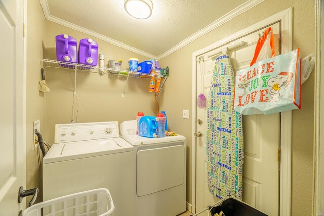 laundry room featuring a textured ceiling, ornamental molding, and washer and dryer