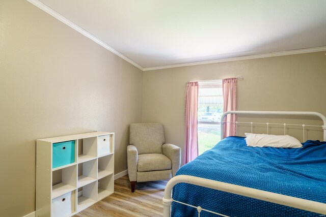 bedroom with crown molding and hardwood / wood-style floors