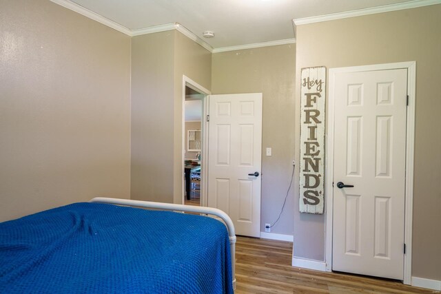 bedroom with hardwood / wood-style flooring and ornamental molding