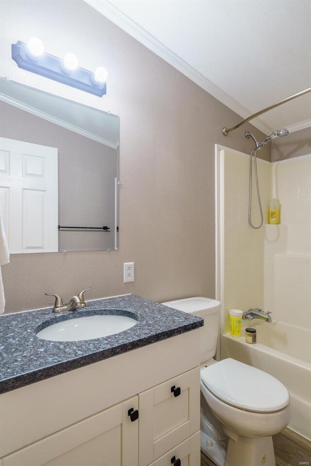 full bathroom featuring shower / bathing tub combination, hardwood / wood-style floors, ornamental molding, vanity, and toilet