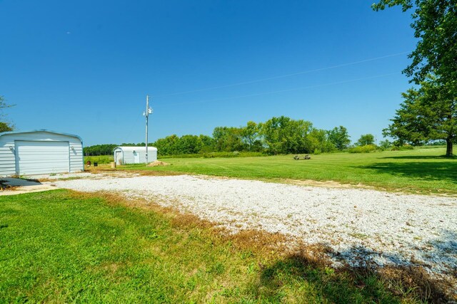 view of yard featuring a garage and an outdoor structure