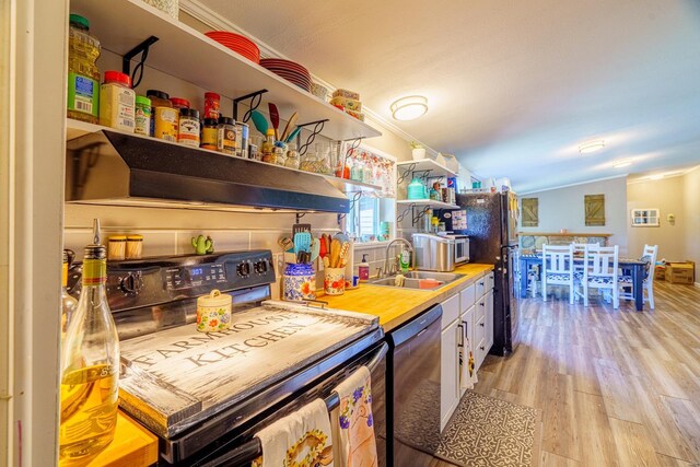 kitchen featuring sink, light hardwood / wood-style floors, ornamental molding, and black appliances