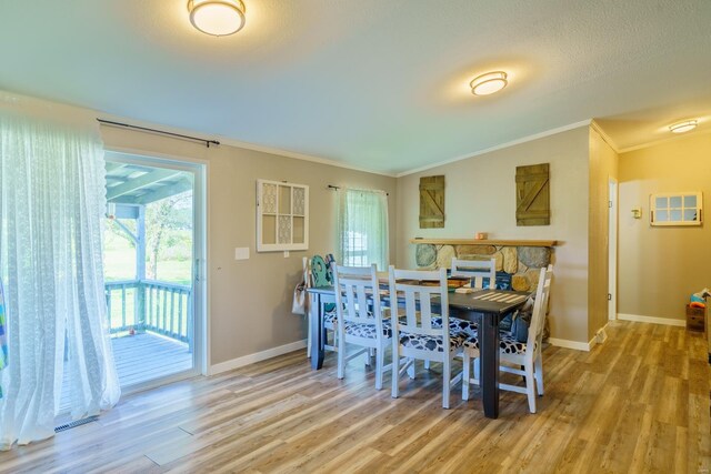 dining room with baseboards, ornamental molding, a wealth of natural light, and wood finished floors