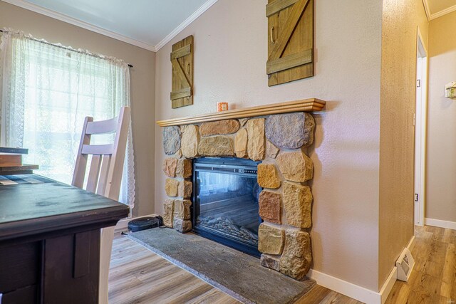 interior space featuring light hardwood / wood-style floors, crown molding, and a fireplace