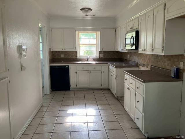 kitchen with sink, tasteful backsplash, dishwasher, light tile patterned floors, and white cabinets