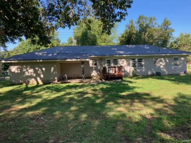 view of front of house with a wooden deck and a front yard