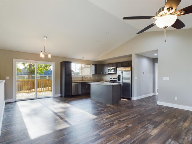 kitchen with stainless steel appliances, dark brown cabinetry, a kitchen island, sink, and dark wood-type flooring