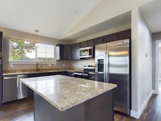 kitchen with dark hardwood / wood-style floors, a kitchen island, vaulted ceiling, sink, and stainless steel appliances