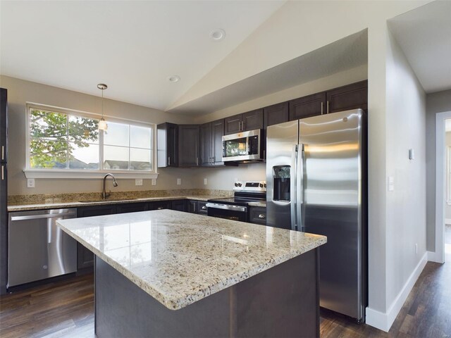 kitchen with decorative light fixtures, a kitchen island, sink, dark brown cabinets, and appliances with stainless steel finishes