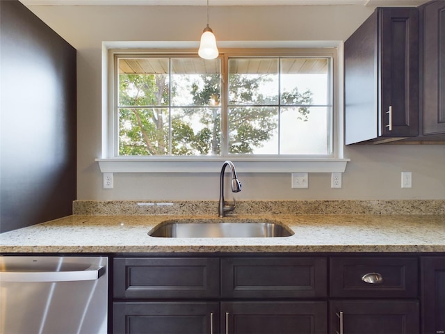 kitchen featuring sink, dark brown cabinets, light stone countertops, dishwasher, and pendant lighting