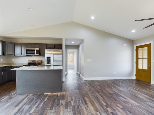 kitchen with vaulted ceiling, a center island, dark wood-type flooring, and stainless steel appliances