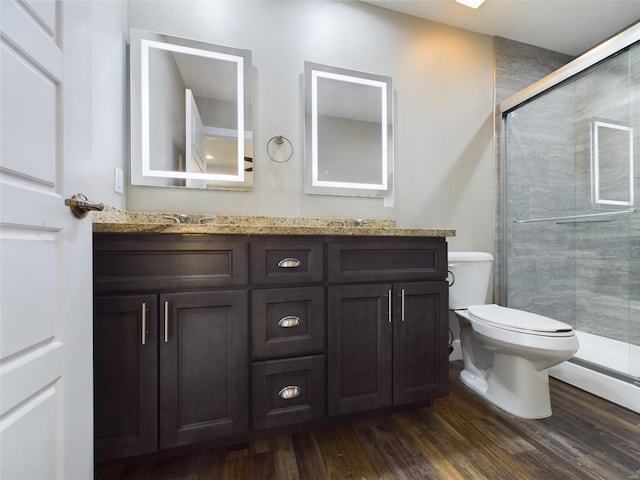 bathroom featuring hardwood / wood-style flooring, dual bowl vanity, walk in shower, and toilet