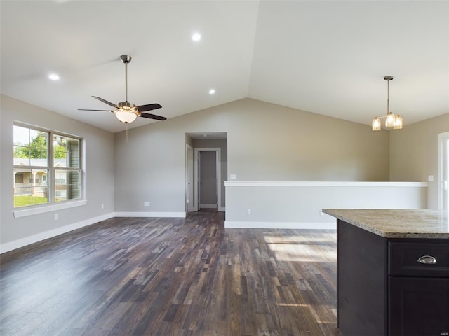 spare room with lofted ceiling, ceiling fan with notable chandelier, and dark hardwood / wood-style flooring