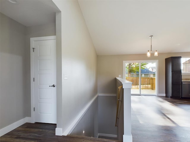 stairway with a notable chandelier and hardwood / wood-style flooring