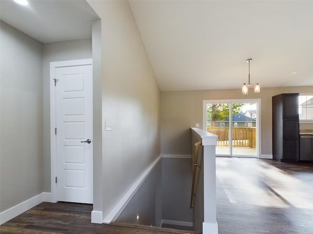 staircase with hardwood / wood-style flooring and an inviting chandelier