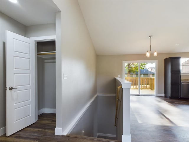 stairway with an inviting chandelier and hardwood / wood-style flooring