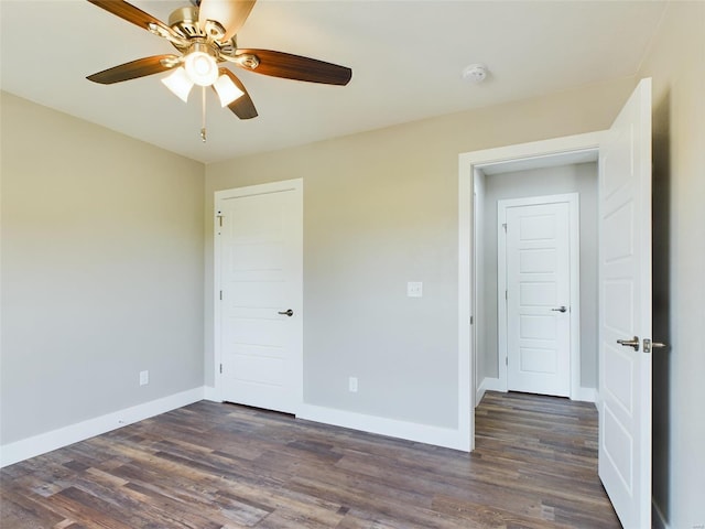 unfurnished bedroom featuring ceiling fan and dark hardwood / wood-style floors