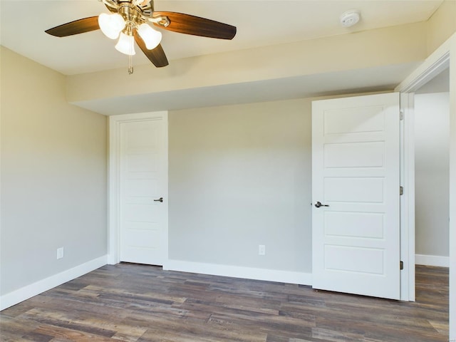 spare room featuring ceiling fan and dark wood-type flooring