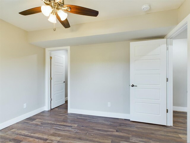 spare room featuring dark wood-type flooring and ceiling fan