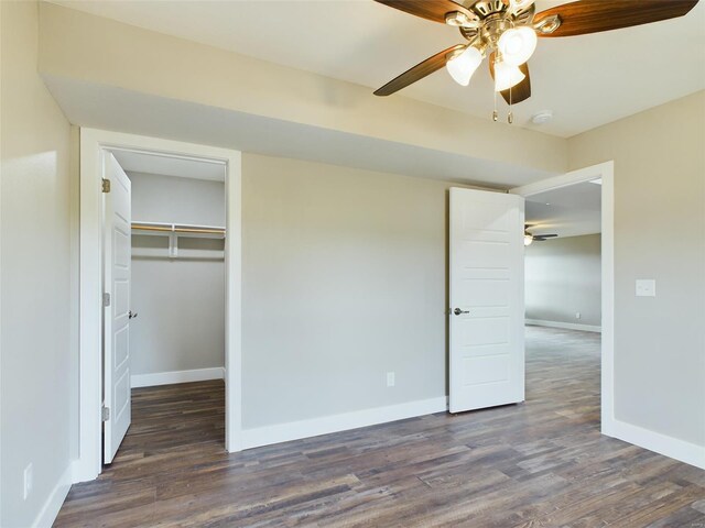 unfurnished bedroom with ceiling fan, dark wood-type flooring, and a closet