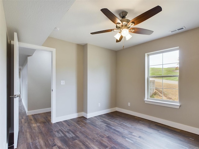 empty room featuring ceiling fan and dark hardwood / wood-style flooring