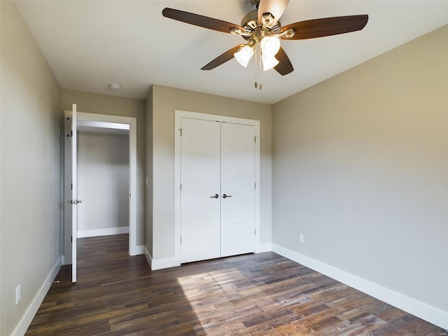 unfurnished bedroom with ceiling fan, a closet, and dark wood-type flooring