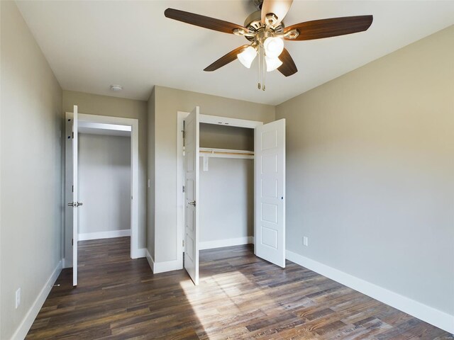 unfurnished bedroom with ceiling fan, dark wood-type flooring, and a closet