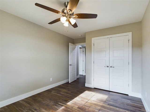 unfurnished bedroom featuring ceiling fan, dark wood-type flooring, and a closet