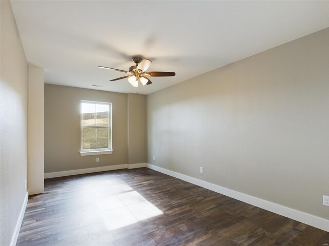 empty room featuring ceiling fan and dark wood-type flooring