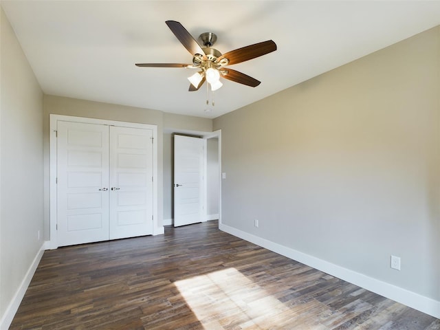 unfurnished bedroom featuring dark hardwood / wood-style flooring, a closet, and ceiling fan