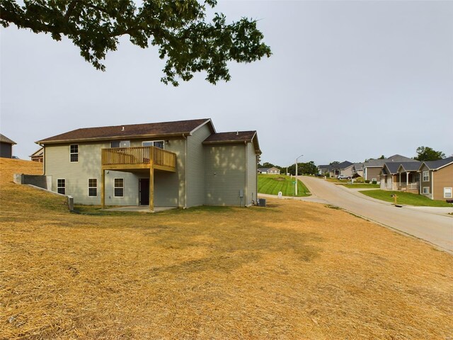 back of property featuring a yard and a balcony