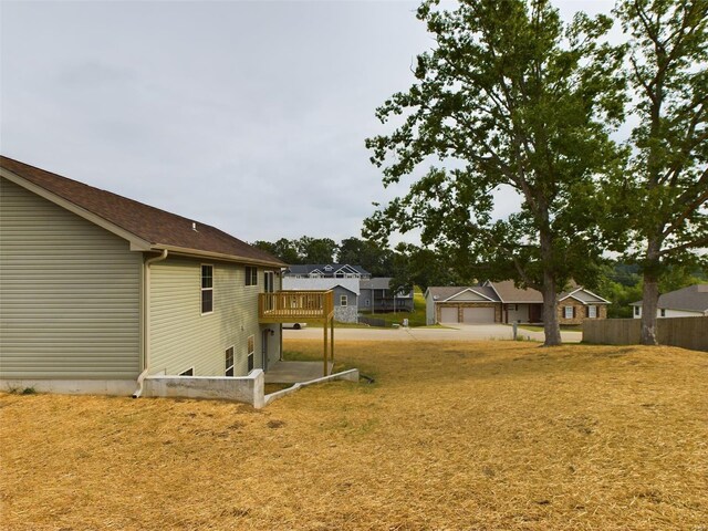 view of yard with a garage and a wooden deck