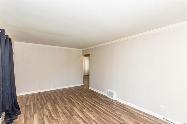 empty room with hardwood / wood-style flooring and crown molding