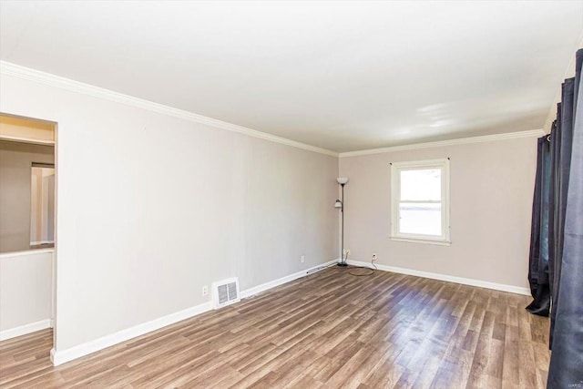 spare room featuring crown molding and hardwood / wood-style floors