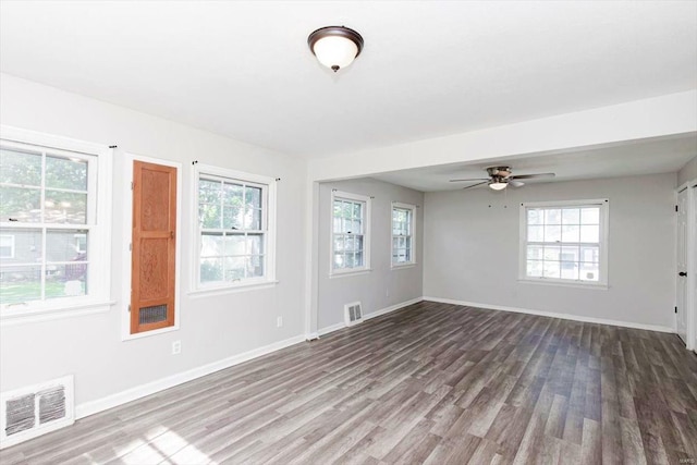 spare room featuring ceiling fan, a healthy amount of sunlight, and hardwood / wood-style flooring