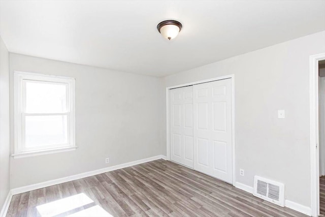 unfurnished bedroom with a closet and wood-type flooring