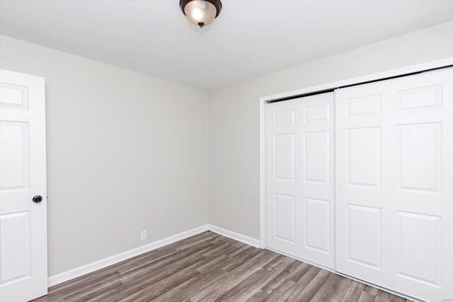 unfurnished bedroom featuring hardwood / wood-style flooring and a closet