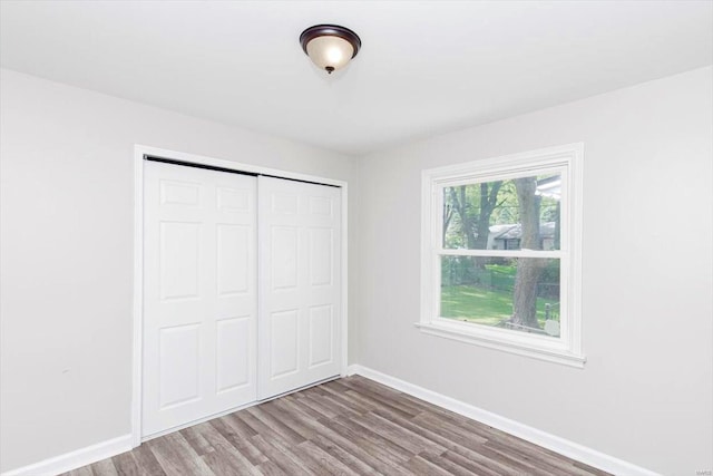 unfurnished bedroom featuring hardwood / wood-style floors and a closet