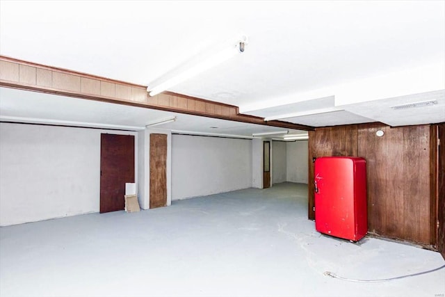 basement featuring wood walls